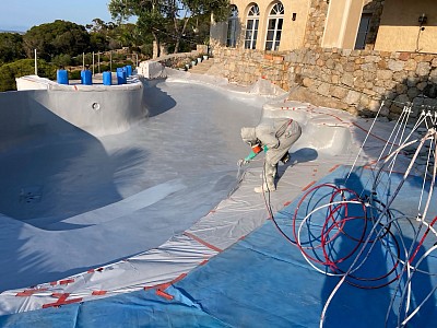 Revêtements stratifiés polyester gelcoats & topcoats à Calvi Protégez votre piscine avec SP REVETEMENTS en Haute-Corse  Le revêtement stratifié polyester Gelcoat + Topcoat reste la méthode incontournable pour la construction de bateaux et cuvelages depuis les années 70. La résine polyester armée de fibre de verre forme une coque rigide adhérente parfaitement au support de la piscine à l'aide d'un primaire d'accrochage. Le rendu final est un véritable cuvelage faisant corps avec la structure du bassin. Un choix judicieux dans le cadre d'une rénovation car l'ensemble de la structure fragilisée par le temps sera renforcée. Afin de remplacer votre liner par une coque réalisée manuellement, sur mesure et sur site. Le Gelcoat Après séchage de la résine polyester et de la fibre de verre  est appliqué le Gelcoat et en deuxième couche le Topcoat. Le choix de la couleur se fera sur la base du style recherché, de l'environnement du bassin et la volonté esthétique du propriétaire. En remplacement du liner, l'avantage du Gelcoat est constaté rapidement: Totalement lisse et sans plis, un robot nettoyeur pourra longer les parois de la piscine sans encombres. La personne chargée de l'entretien de la piscine appréciera l'aisance du nettoyage de la surface du bassin.  En cas d'agression extérieure, le Gelcoat est facile à réparer. Il suffit d'un ponçage de la partie endommagée suivi de l'application de nouvelles couches de Gelcoat. La partie endommagée ainsi réparée sera parfaitement étanche et invisible l'œil nu. Avantages de la résine avec Gelcoat * Adapté pour bassins aux formes complexes * Absence de plis (Hygiène améliorée) * Imputrescible * Idéal en rénovation de piscine * Protège la structure du bassin * Prévient l'apparition d'algues * Facile à réparer en cas de dommages. * Facile à nettoyer Inconvénients de la résine avec Gelcoat * Plus cher que le liner * Requiert une véritable mise en œuvre par un spécialiste et la durée du chantier peut aller de 2 à 3 semaines.